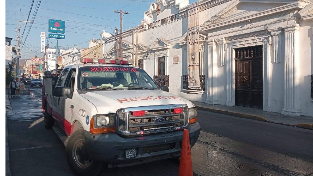 Una camioneta de rescate de los Bomberos está estacionada frente al Palacio Municipal de Zinapécuaro, decorado con un estandarte de 