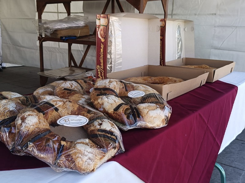 Roscas de reyes de sabores exhibidas en una mesa.