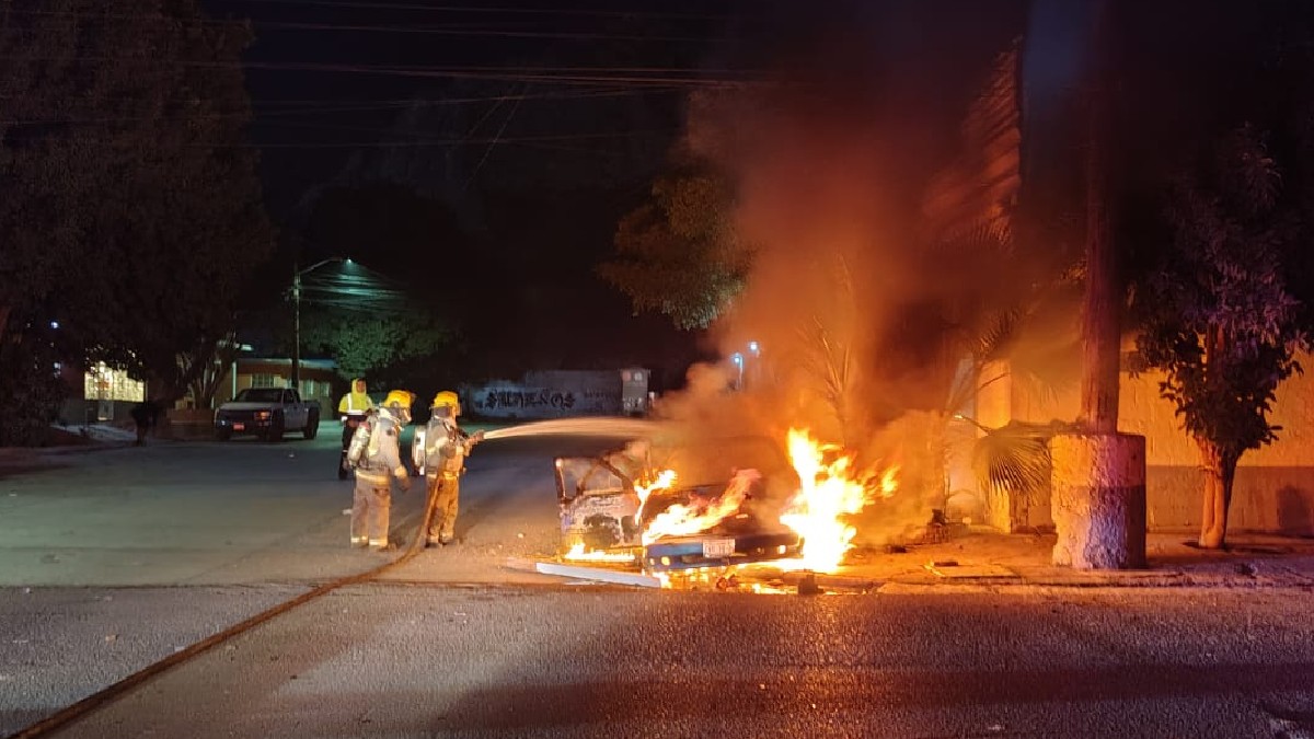 Foto de bomberos combatiendo el fuego tras el choque, reportan lesionados.