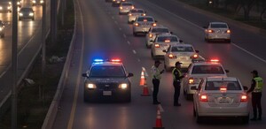 Se observan muchos carros en carretera y unos policías de tránsito que están a un lado.