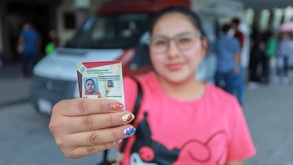 una mujer muestra su licencia de conducir de puebla