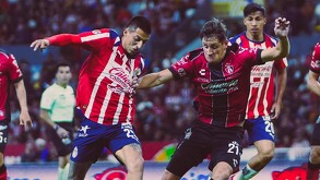 Roberto Alvarado disputando un balón en el partido amistoso contra Atlas.