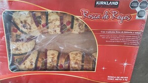 Se observa una rosca de reyes dentro de una caja roja de la marca Kirkland.