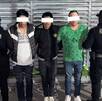 Tres sujetos detenidos y policías en los lados