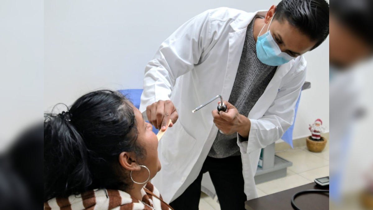 Médico revisando a una mujer en un consultorio.