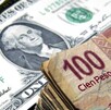 Dólar estadounidense y billete de 100 pesos mexicanos.