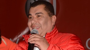 El político Javier López Zavala hablando frente a un micrófono, y de fondo un escudo del PRI.