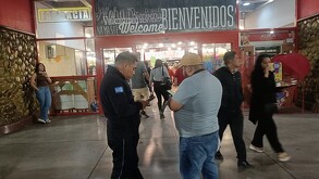 Supermercado, exterior en donde ocurrió una tragedia, un hombre se prendió en fuego, gente alrededor mirando los hechos.