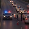 Se observan muchos carros en carretera y unos policías de tránsito que están a un lado.