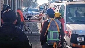 Mujer siendo atendida por paramédicos y trasladada a bordo de una ambulancia.