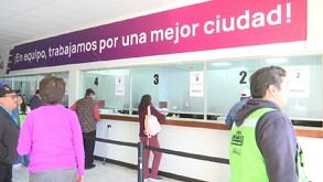 Se observa a unas personas paradas haciendo fila.