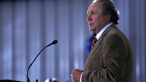 Michael Reagan hablando ante un micrófono.