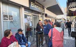 Personas haciendo fila afuera de Banco Bienestar