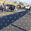 Se observan varios autos, dos destrozados, sobre una carretera; hay varias personas alrededor.