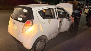 Se observa un carro de la marca Spark color gris con daños materiales.