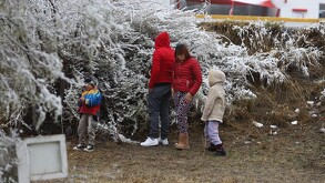 Se observa a una mujer, un hombre y unos niños con chamarras, hay nieve.