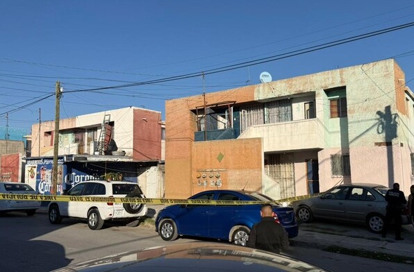 Se observan varias casas, con cinta amarilla de precaución y unas personas alrededor.