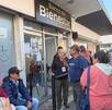 Personas haciendo fila afuera de Banco Bienestar