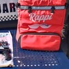 Mochila de reparto de Rappi junto a artefactos asegurados por la Policía de Michoacán delante de una patrulla