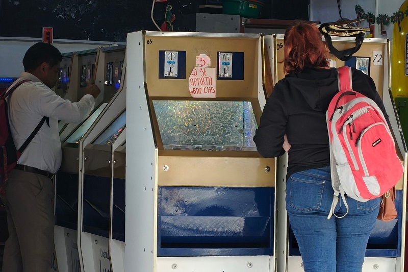 Una mujer juega en una máquina tragamonedas instalada en un local de Puebla.