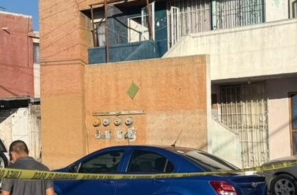 Se observan unas casas, unas personas afuera y una cinta amarilla de precaución.