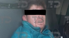 Se observa a un hombre con los ojos cubiertos y que viste una chamarra azul.