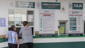 dos personas en un verificentro en puebla