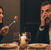 Un hombre y una mujer cenando en una mesa de restaurante