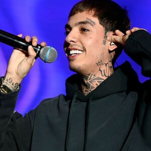 Natanael Cano en pleno concierto con fondo morado.