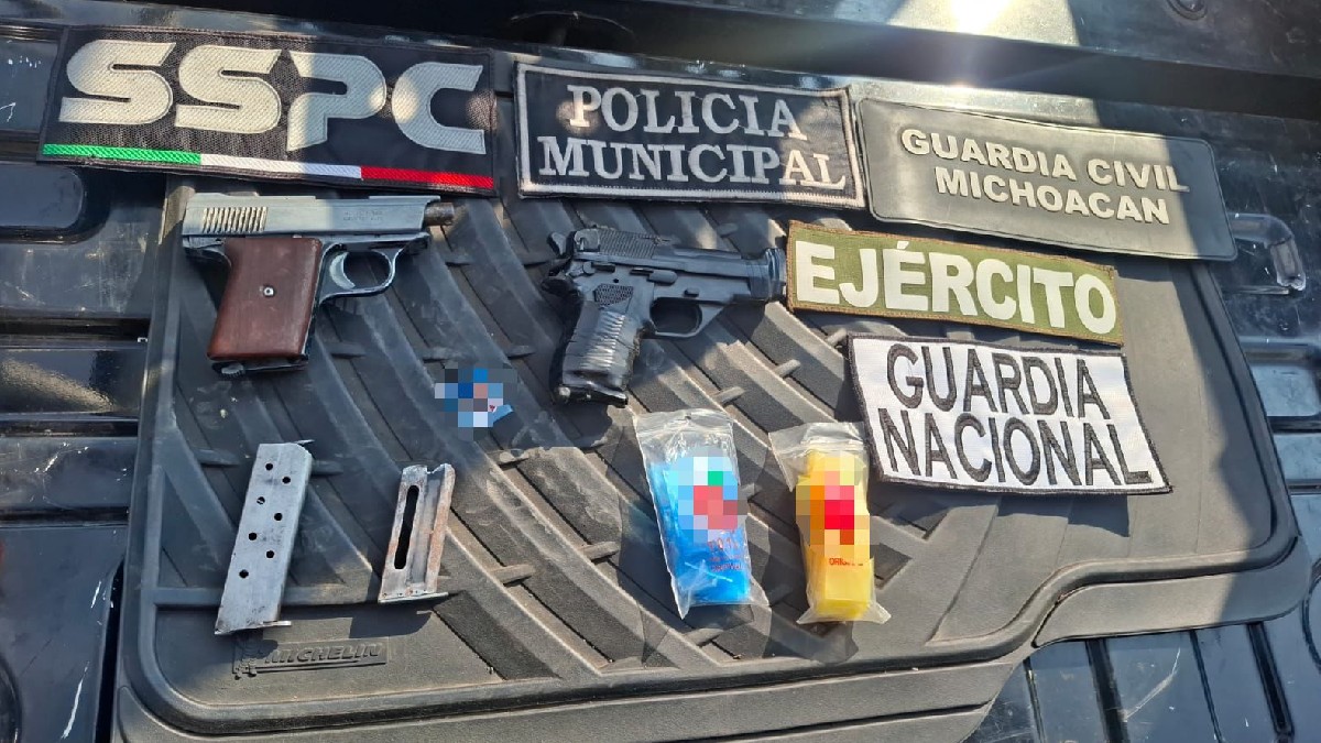 Elementos de la Guardia Nacional y SSPC custodian a tres hombres detenidos frente a una patrulla, tras un operativo de seguridad en Michoacán.