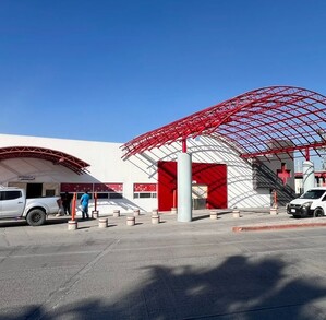Se observa un edificio color blanco con roja y una cruz roja.
