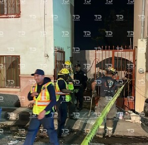 Se observa a unos policías afuera de un domicilio y una cinta amarilla de precaución.