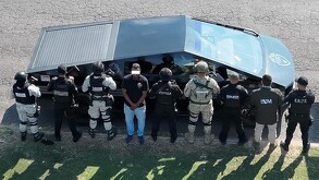 Hombre identificado como El Parce en medio de varios policías estatales de Jalisco parados delante de una patrulla Cybertruck en Zapopan