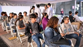 Jovenes esperando en sillas a las afueras de la UDG para ser vacunados contra el sarampión