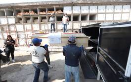 Personas en lápidas de panteon trabajando