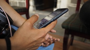 Una persona utiliza su celular en un parque público.