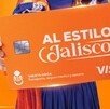 Tarjeta Única de Jalisco color naranja con el eslogan Al Estilo Jalisco siendo sostenida por una mujer con traje típico tapatío