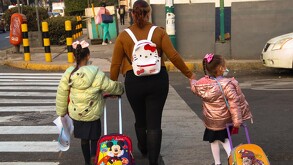Mujer llevando a sus hijas a la escuela en la Ciudad de México.
