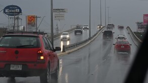 Carros transitando en Torreón, fuerte lluvia y frío.