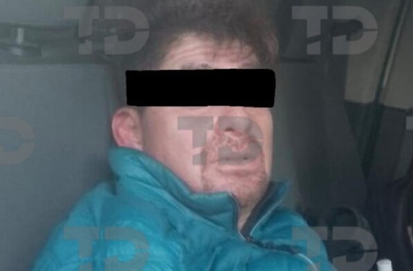 Se observa a un hombre con los ojos cubiertos y que viste una chamarra azul.