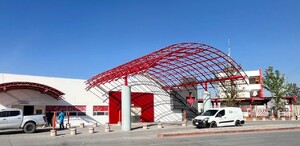 Se observa un edificio color rojo con blanco y una cruz roja.