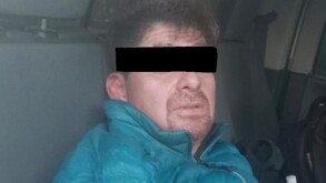 Se observa a un hombre con ojos tapados y con chamarra azul.