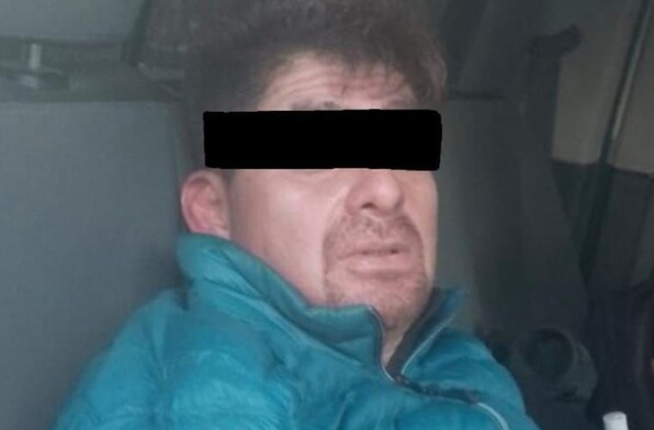 Se observa a un hombre con ojos tapados y con chamarra azul.