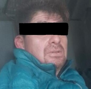 Se observa a un hombre con ojos tapados y con chamarra azul.