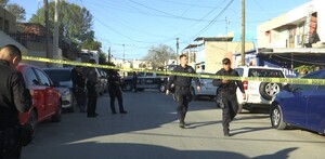 Se observan a varios hombres vestidos de negro caminando sobre la calle y hay una cinta amarilla de precaución.