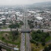 Vista aérea de un trébol vial sobre la Avenida López Mateos en Guadalajara, con intenso flujo vehicular y zonas industriales a los costados.