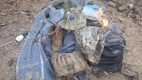 Ropa táctica, una bota café y un sombrero de camuflaje con el parche 