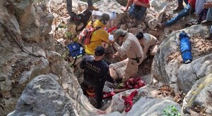 Pobladores de Tequila junto con policías, bomberos y paramédicos realizando el rescate de un adulto mayor en una zona rodeada de piedras de gran tamaño