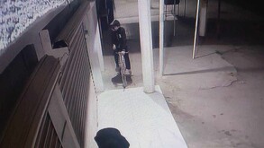 Hombre con sudadera que le cubre hasta el rostro montado en una bicicleta