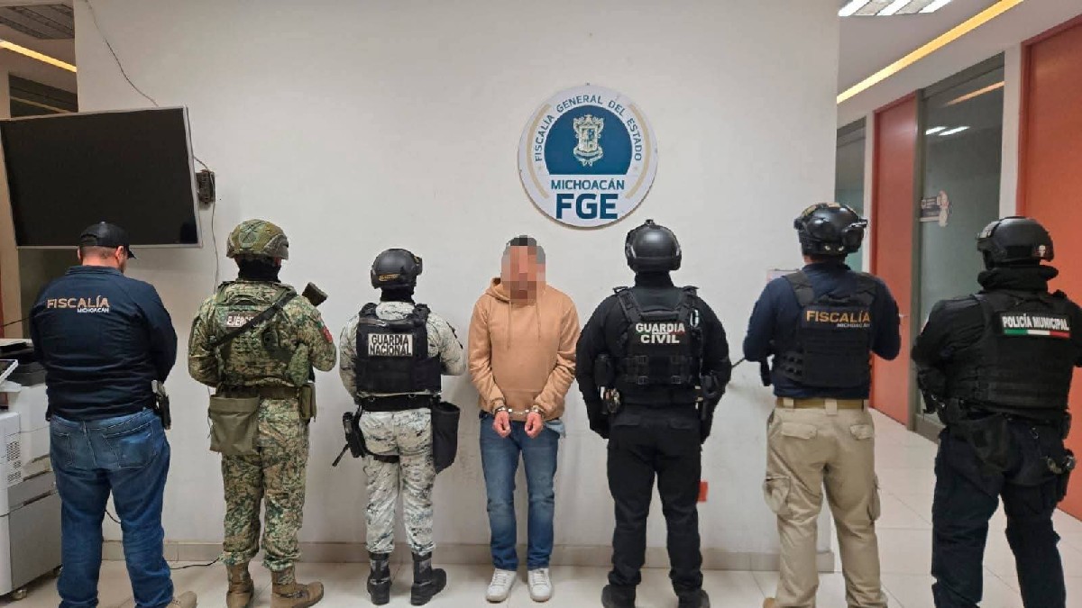 Un hombre esposado aparece de frente, flanqueado por agentes de la Fiscalía de Michoacán, Guardia Nacional y Guardia Civil bajo el logo de la FGE.